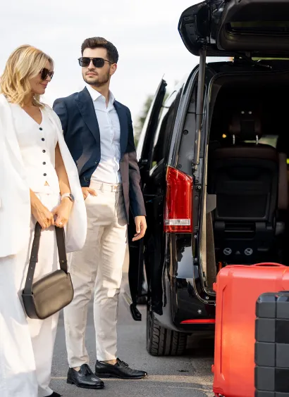 Professional Happy Shuttle driver welcoming family at Paris airport for private transfer